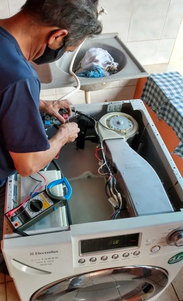 Técnico consertando máquina de lavar de abertura superior