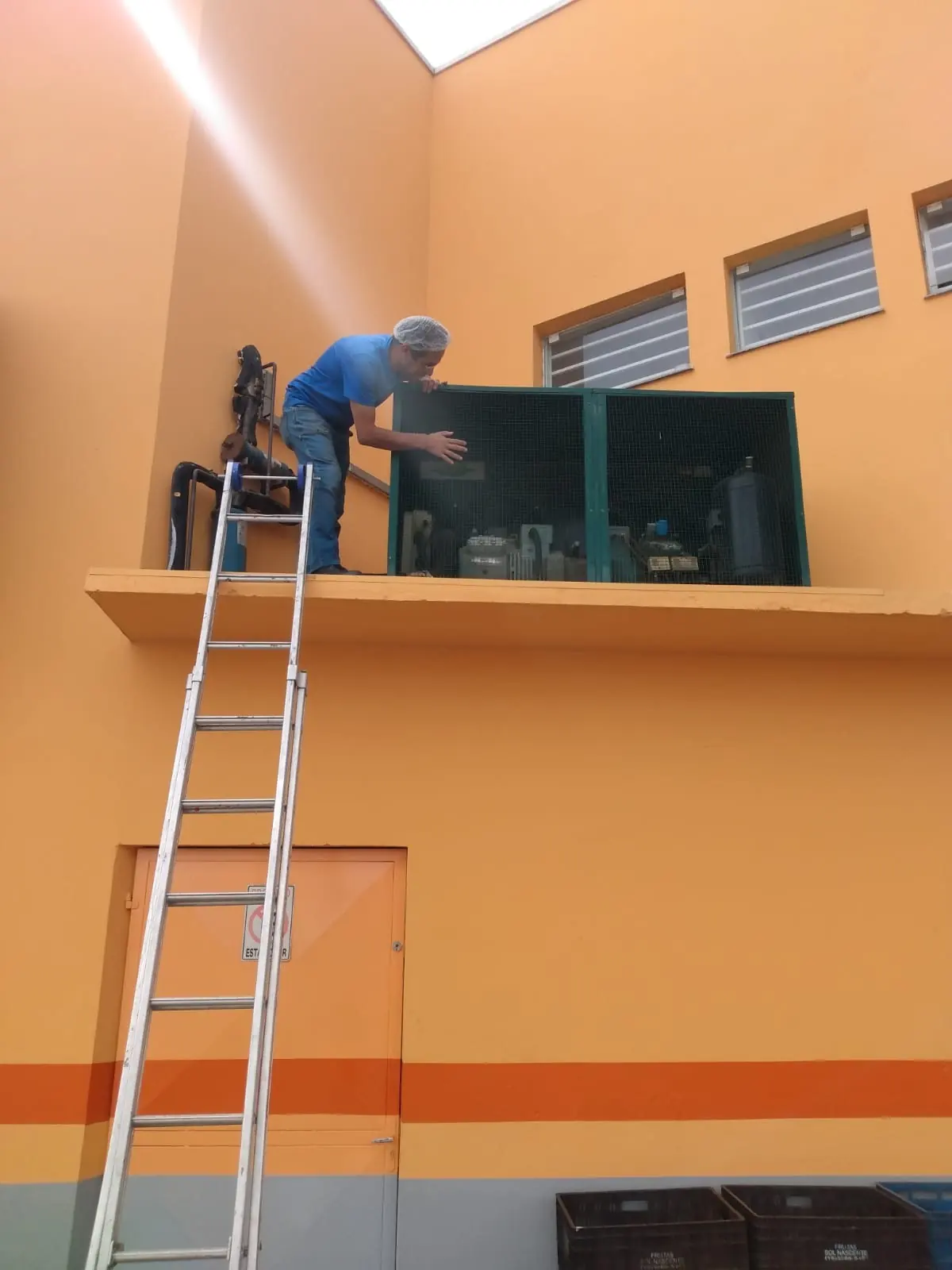 Técnico da Arconfrio realizando manutenção de refrigeração em altura